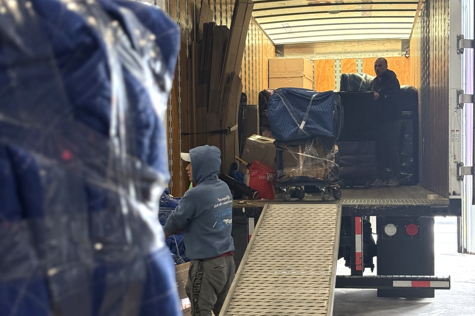 What movers won't move: Magical Moving crew loading blanket-wrapped furniture up the truck ramp, no banned items aboard