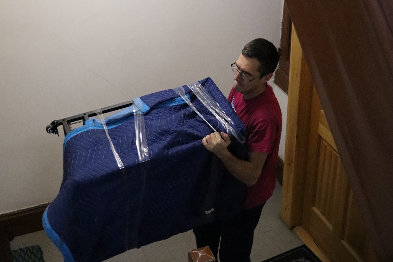 Magical Moving crew pivoting a wrapped piece on a NYC walk-up stair landing