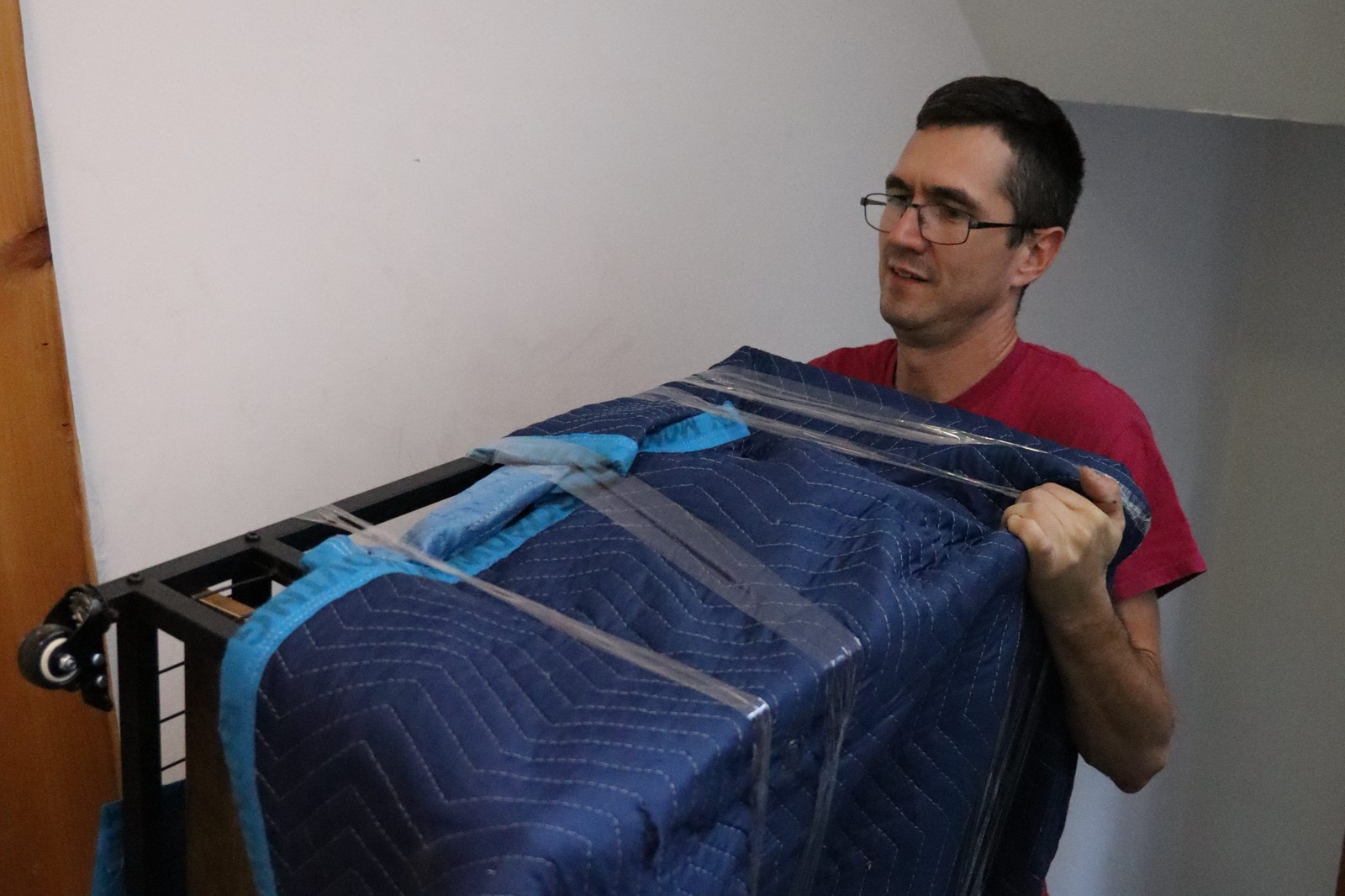 will my couch fit through the door: Magical Moving crew carrying a wrapped piece through a NYC apartment doorway