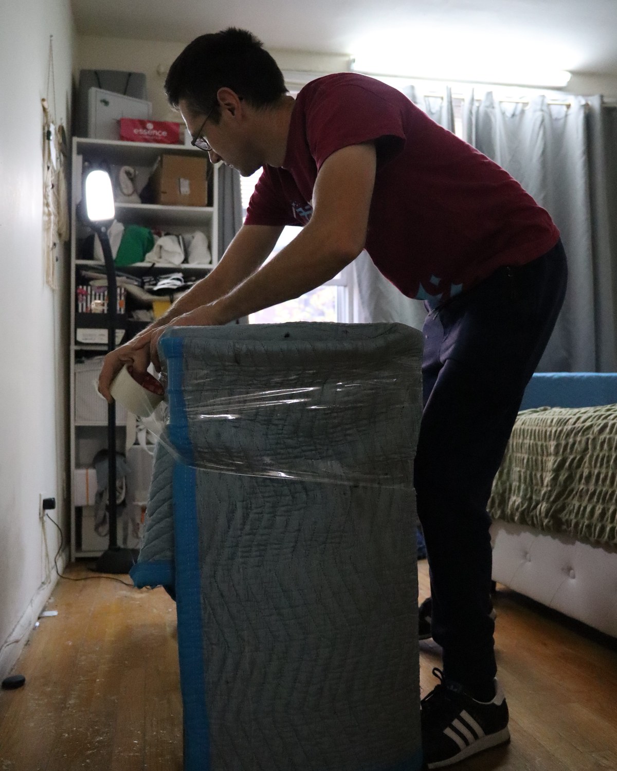 Magical Moving mover wrapping furniture in a blanket and plastic, moving in NYC in November