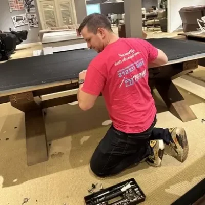 A mover disassembling pool table in the apartment using the tools