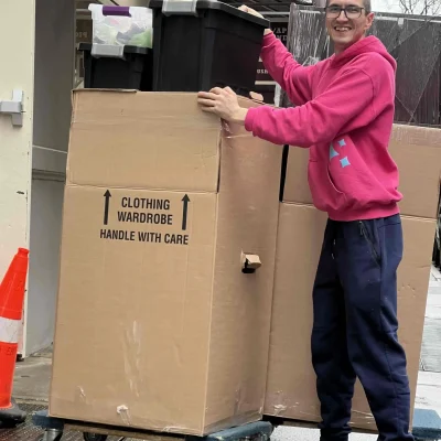 Professional mover in Manhattan using specialized wardrobe boxes for safe clothing transport during a local NYC move.